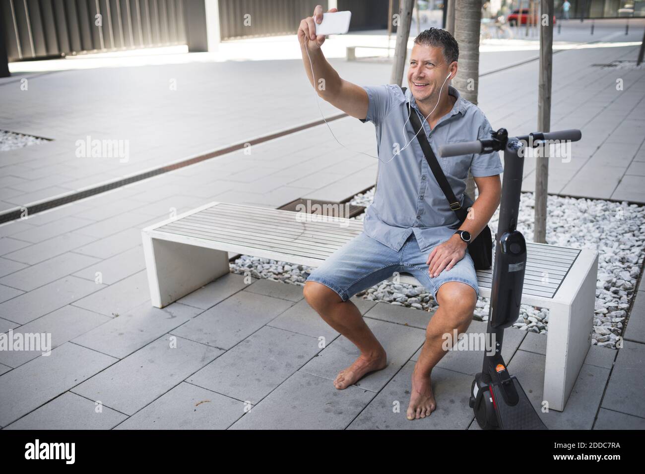 Barefoot man sitting bench hi-res stock photography and images - Alamy