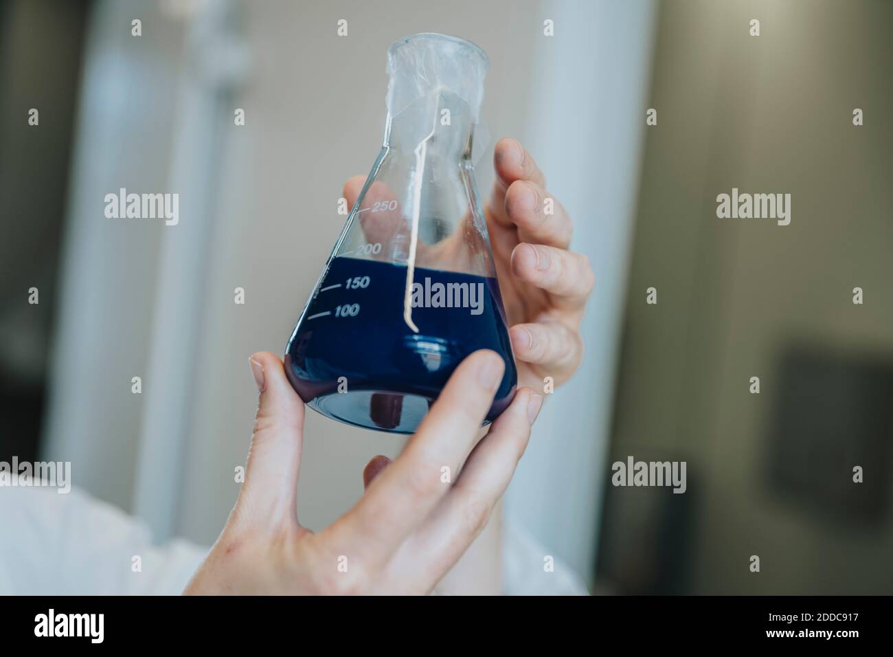 Woman hand holding blue liquid solution at clinic Stock Photo Alamy
