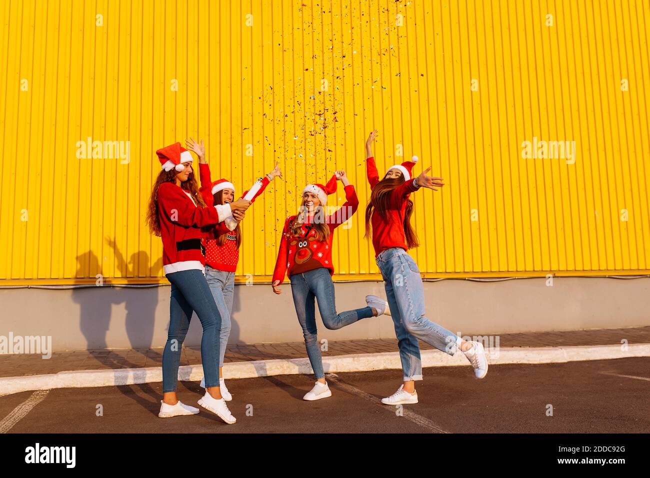 Group of excited happy friends in santa claus hats having fun and ...