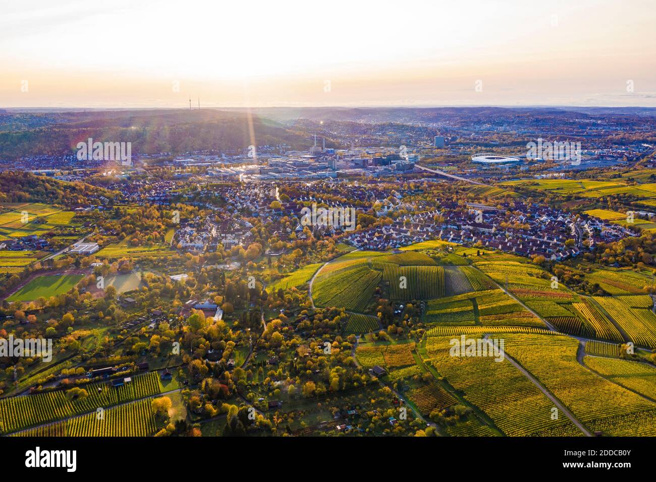 Germany, Baden-Wurttemberg, Stuttgart, Aerial view of vast vineyards in front of countryside town at autumn sunset Stock Photo
