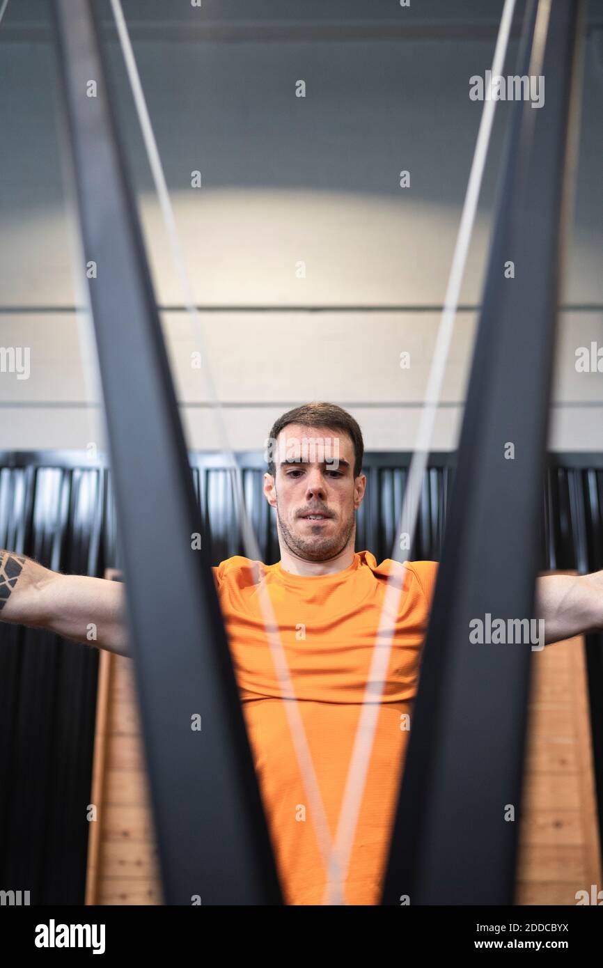Sportsman pulling resistance bands exercise in gym Stock Photo