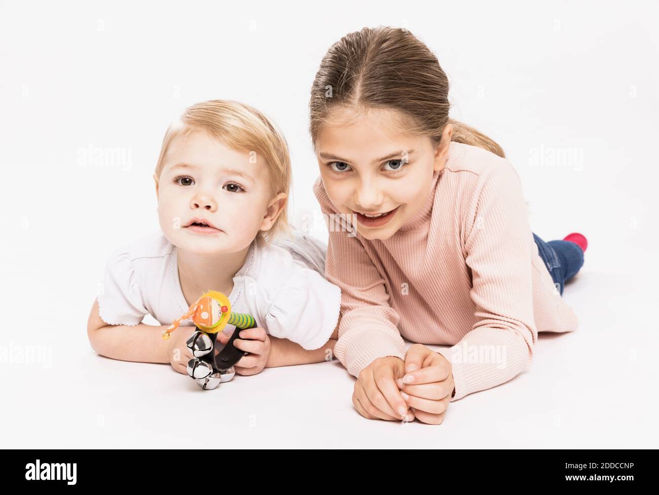 Sisters lying on front in studio Stock Photo