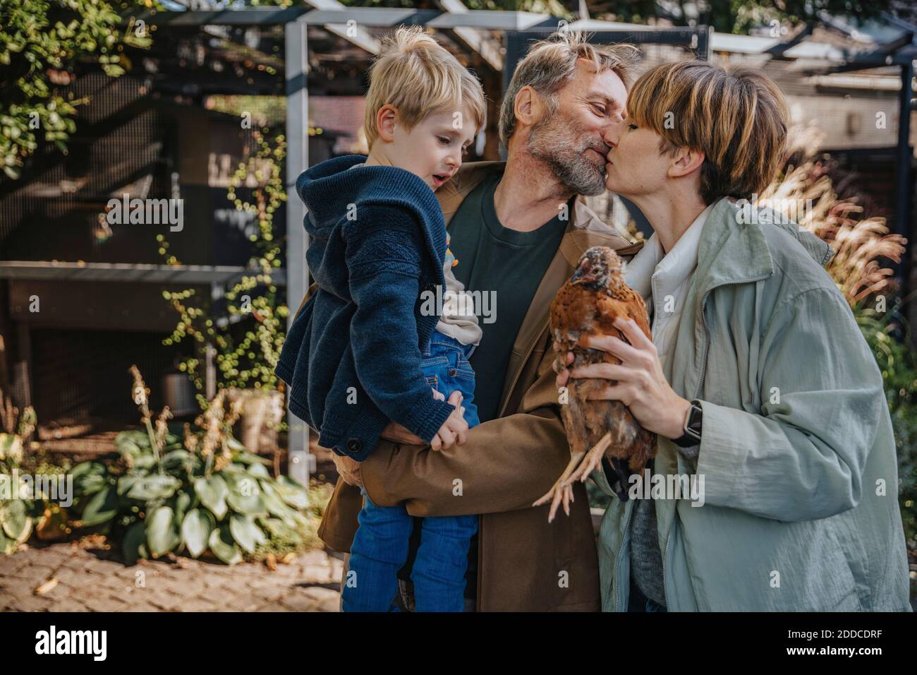 Family with chicken coop standing in back yard Stock Photo