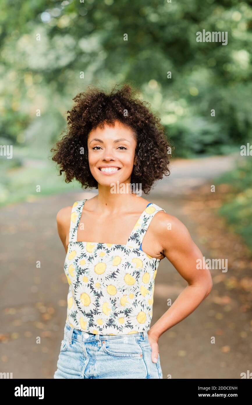 Smiling mid adult woman standing on road at park Stock Photo
