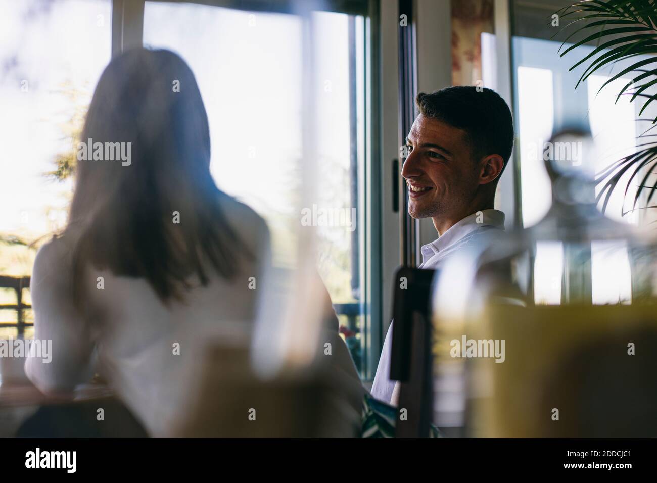 Smiling man talking with woman while sitting at home Stock Photo