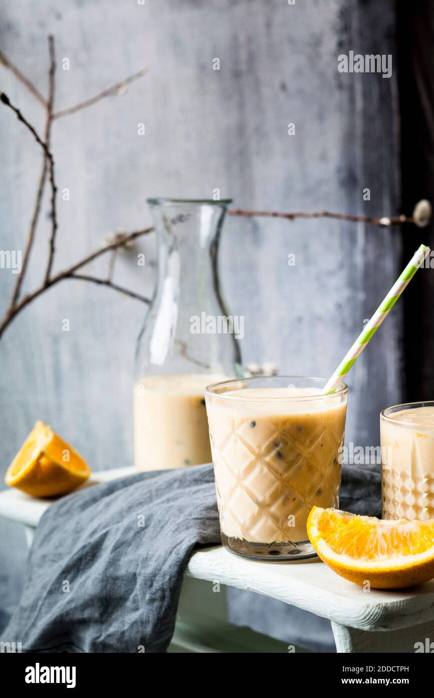 Glasses of fresh fruit smoothie with oranges, bananas, yogurt and grenadine Stock Photo