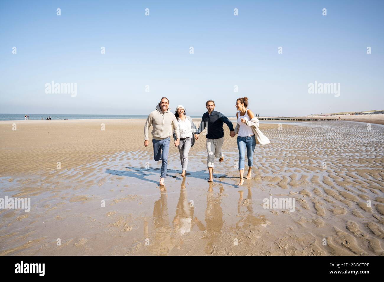 Happy family running on beach hi-res stock photography and images - Alamy