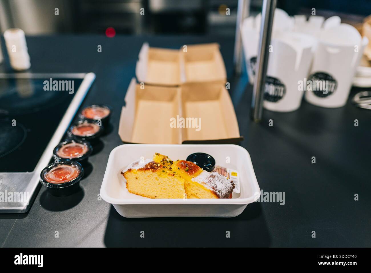 Close-up of fresh bread in take out container by condiments at restaurant kitchen counter Stock Photo