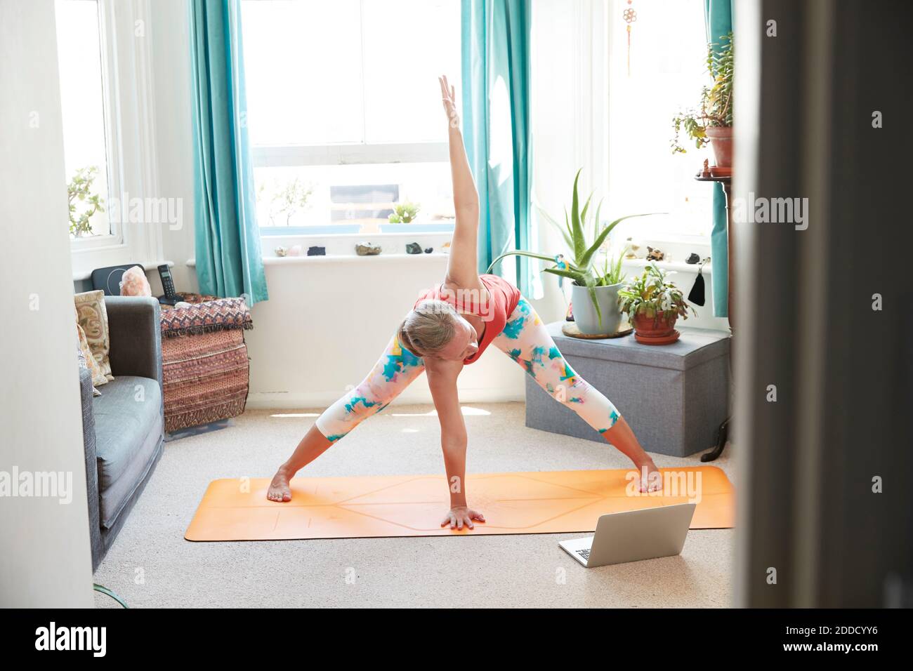 Female athlete doing stretching exercise at home Stock Photo