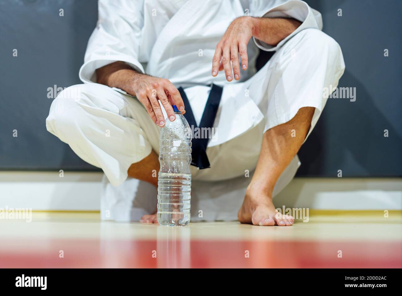 Exhausted mature man holding water bottle in class Stock Photo