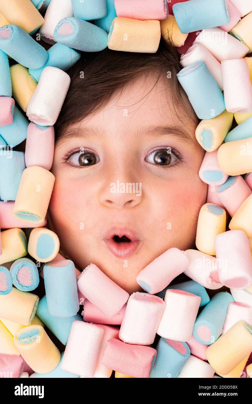 Girl face surrounded with marshmallow looking surprised Stock Photo Alamy