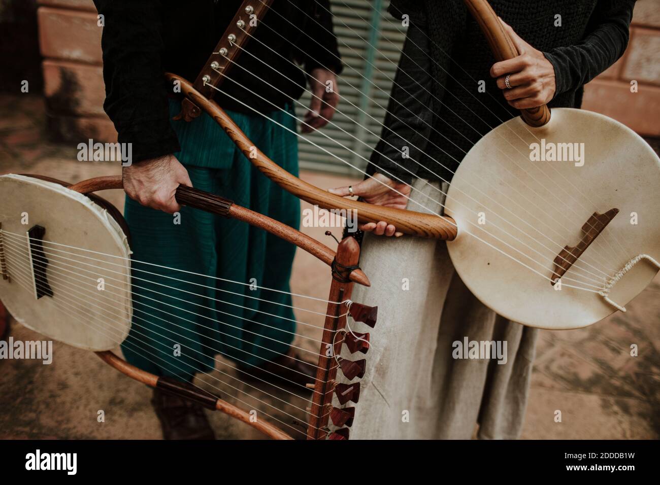 Male and female holding lyra musical instrument outdoors Stock Photo