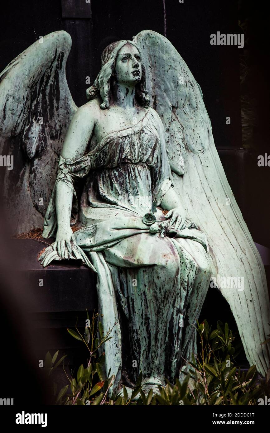 Weathered statue of sitting angel Stock Photo - Alamy