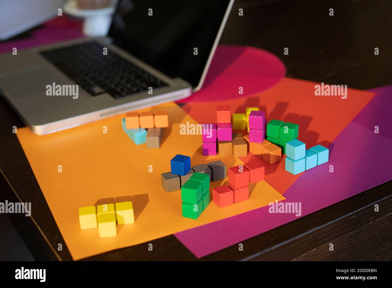 High angle view of multi colored paper, laptop and colorful blocks on table Stock Photo