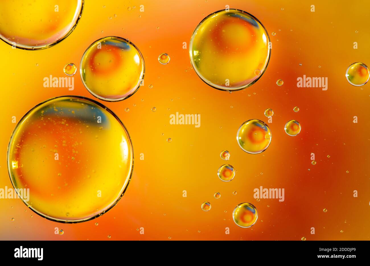 Orange oil drops in water. Bubbles of different sizes on orange abstract background Stock Photo