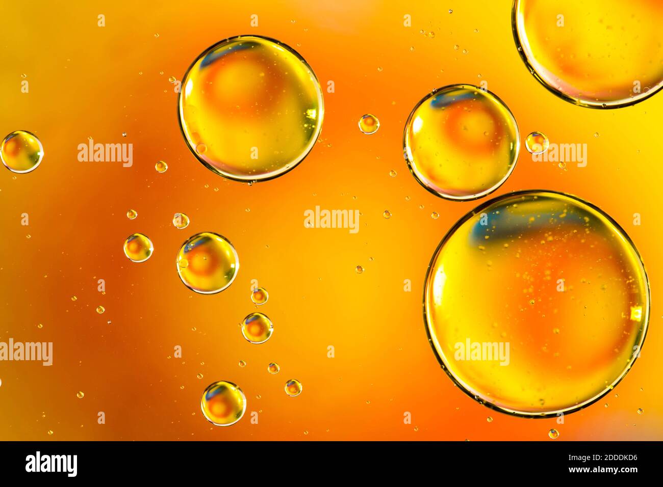 Oil drops in water, bubbles on orange abstract background Stock Photo