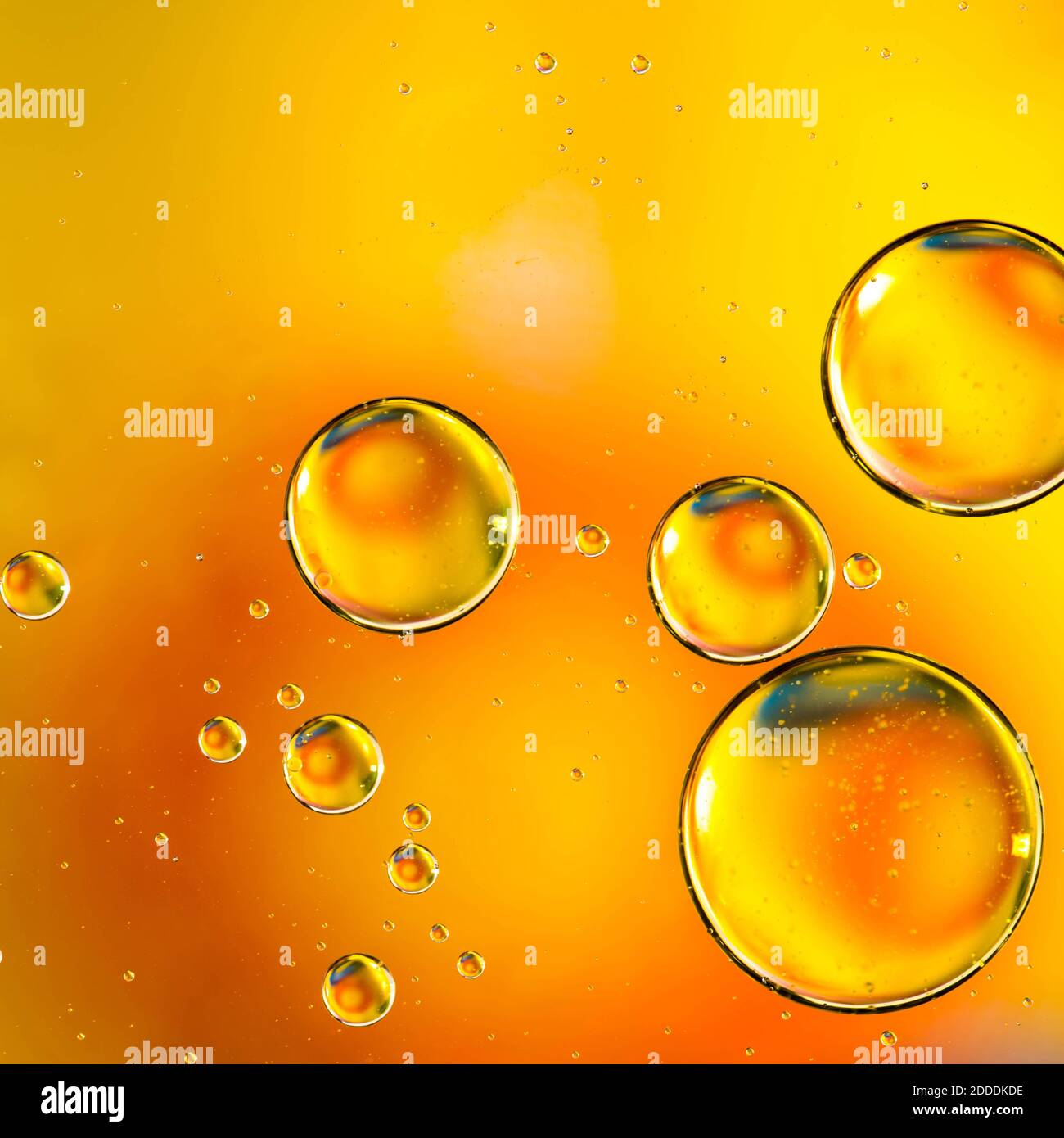 Oil drops in water, bubbles on orange abstract background Stock Photo