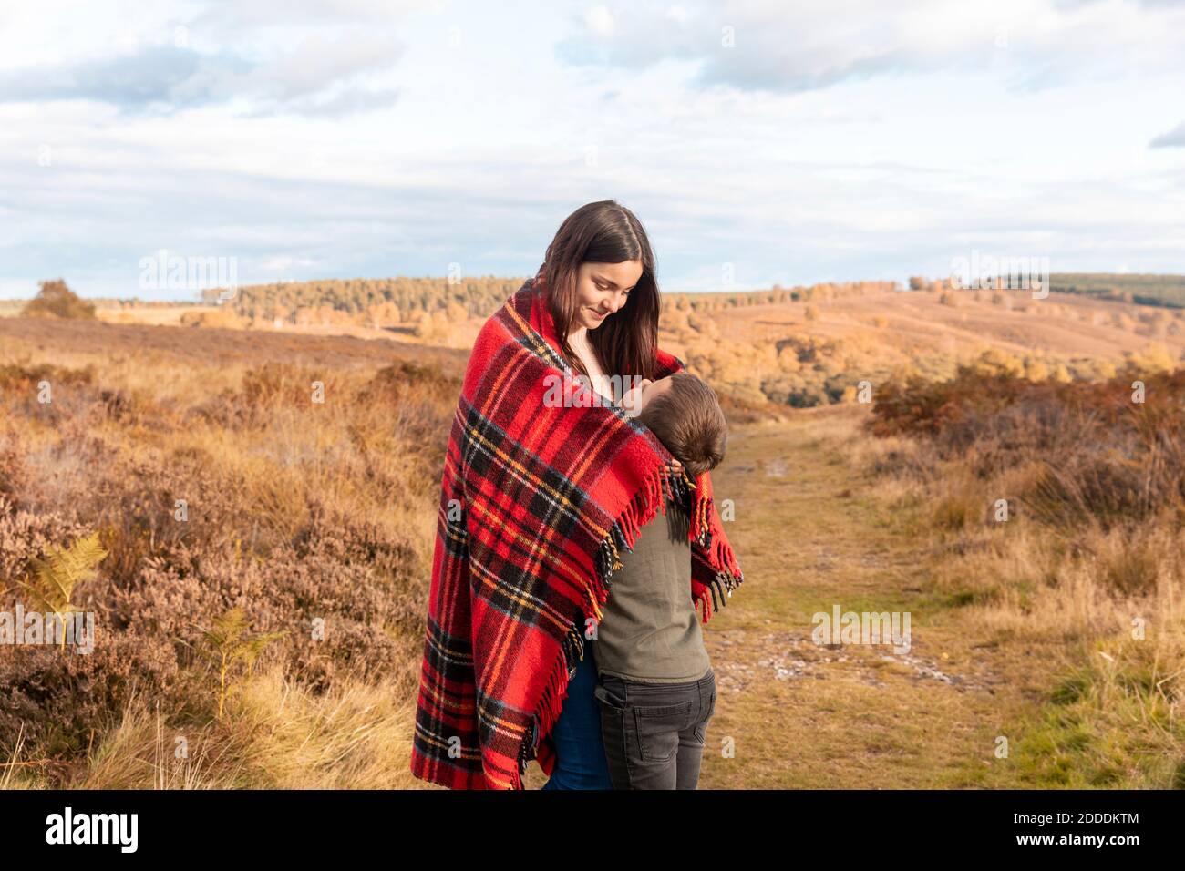Brother and sister embracing each other while standing in park during ...