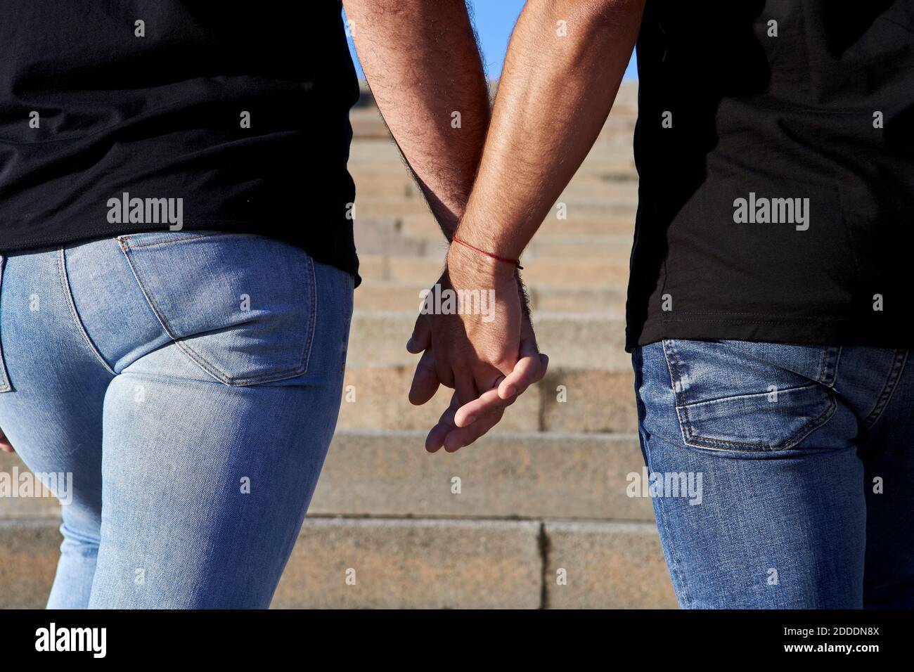 Gay couple holding hands while standing on steps Stock Photo