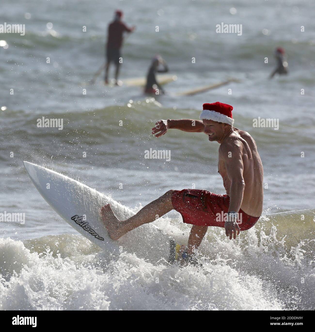 NO FILM, NO VIDEO, NO TV, NO DOCUMENTARY - Surfers don Santa outfits during  the Surfing Santas of Cocoa Beach fundraiser in Cocoa Beach, FL, USA, on  Wednesday, December 24, 2014. Hundreds
