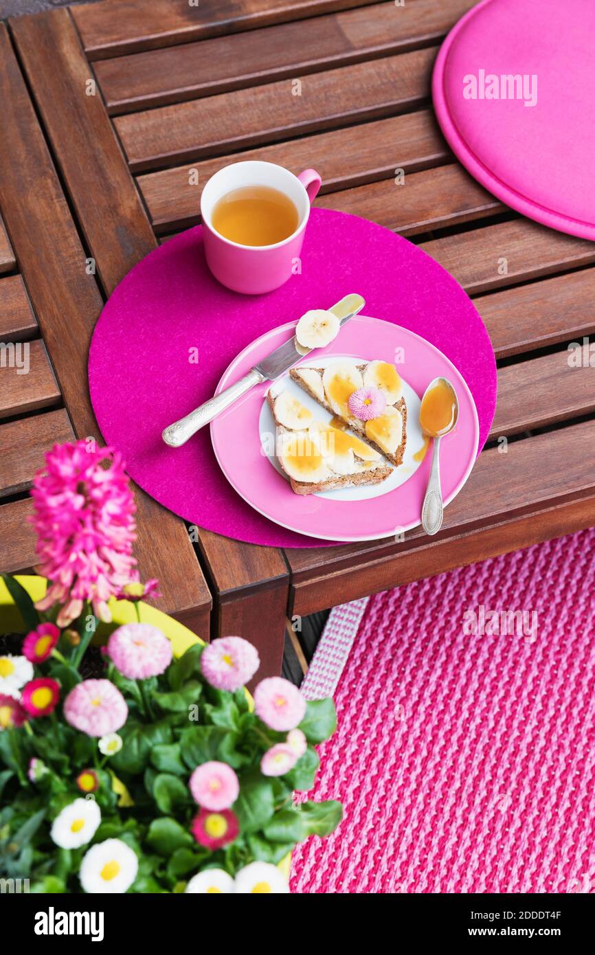 Mug of herb tea and bread slices with bananas and honey Stock Photo