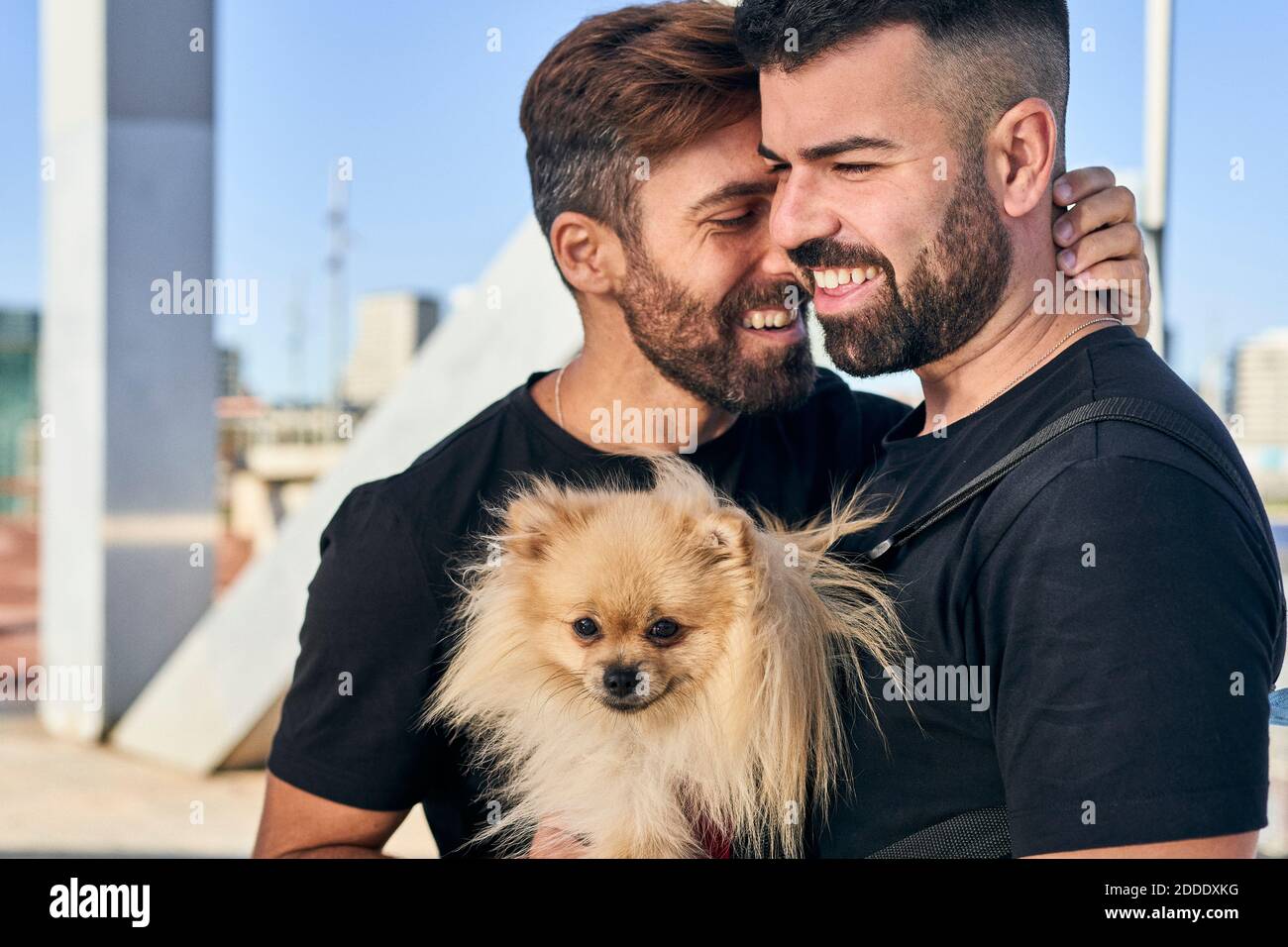 Happy homosexual couple with dog on footbridge Stock Photo - Alamy