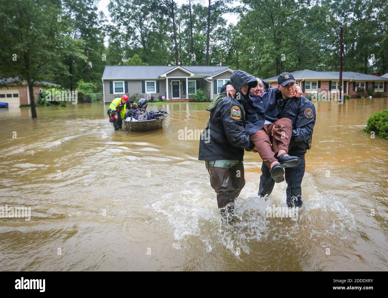 NO FILM, NO VIDEO, NO TV, NO DOCUMENTARY - DNR officer Brett Irvin and  Lexington Co. Deputy Dan Rusinyak carry June Loch to dry land after she was  rescued from her home