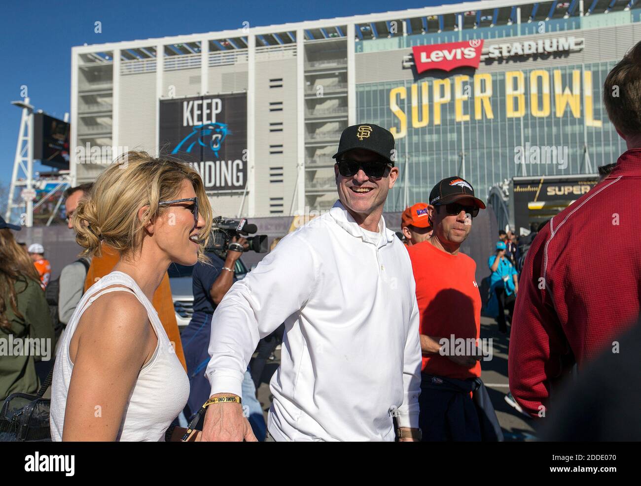 NO FILM, NO VIDEO, NO TV, NO DOCUMENTARY - Former San Francisco 49ers coach  Jim Harbaugh, middle, and his wife, Sarah Harbaugh, left, head into Levi's  Stadium for Super Bowl 50 at
