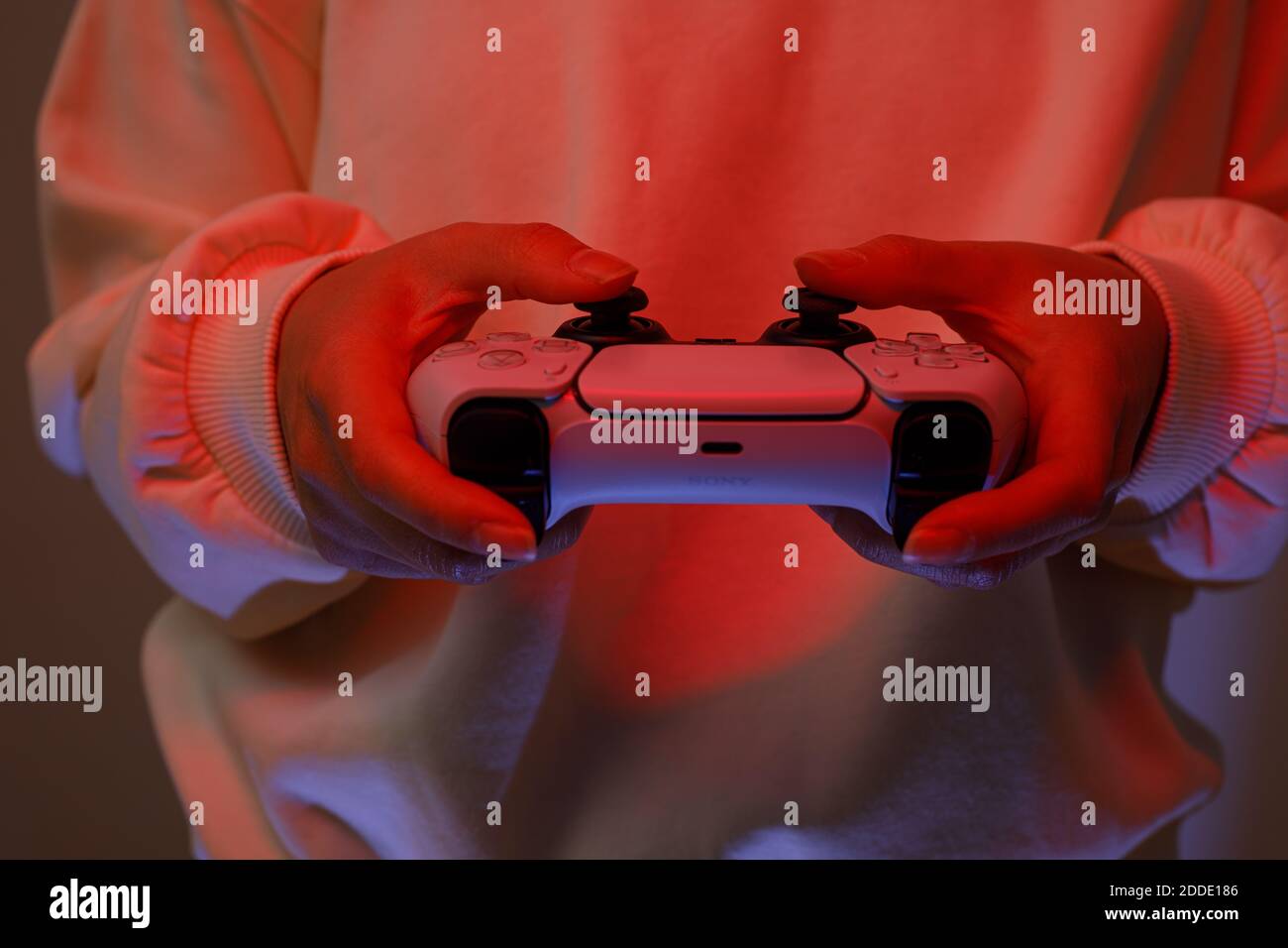 PlayStation 5 Sony reveals PS5 console and games. Dualsense controller. Woman holding joystick Stock Photo
