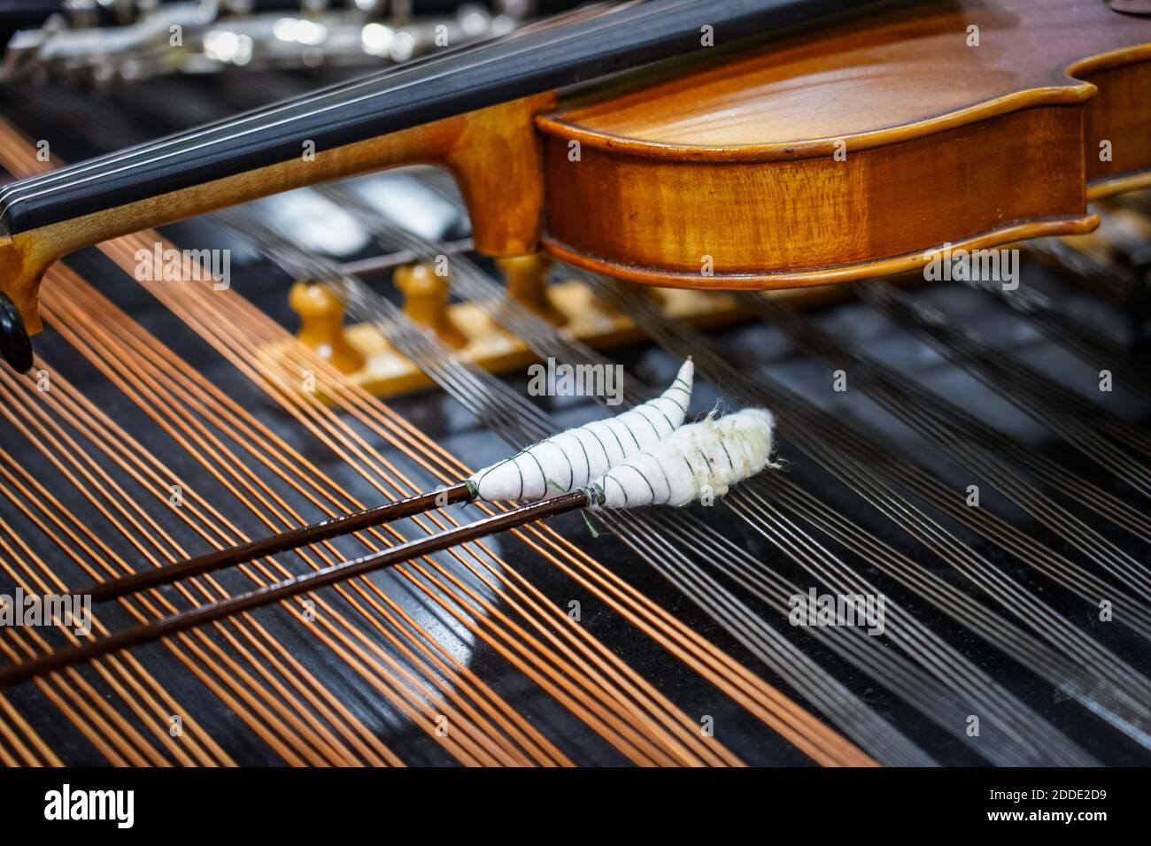 Close up of dulcimer strings and drumsticks with lying violins. Music concept background Stock Photo