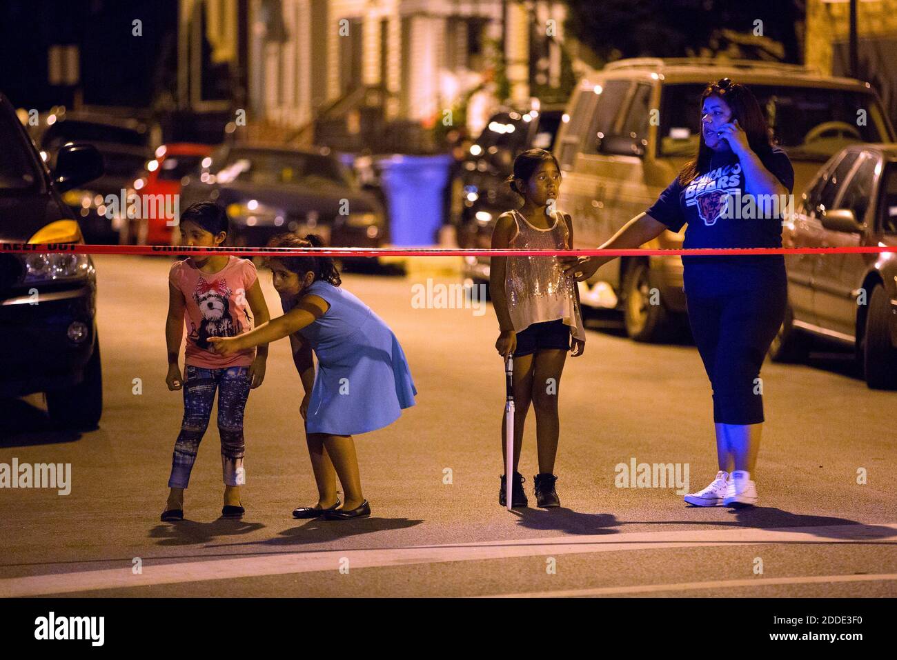 NO FILM, NO VIDEO, NO TV, NO DOCUMENTARY - A woman and three young girls  stand on one side of police tape at the scene of a shooting in the 1900  block