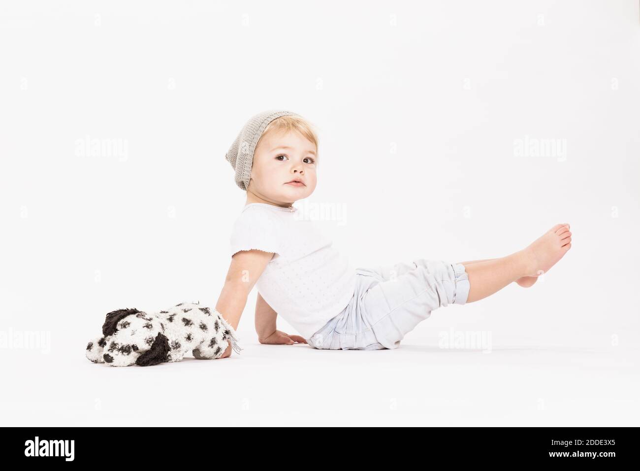 Cute little girl playing with stuffed toy in studio Stock Photo - Alamy