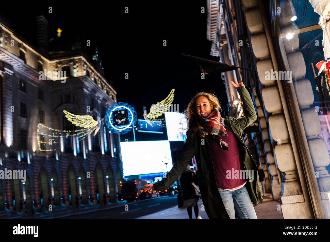 Carefree woman dancing while standing at Regent Street during Christmas in London, UK Stock Photo