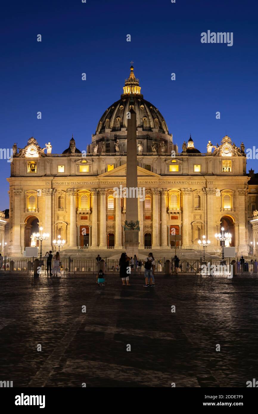 Tourists at St. Peter's Square with illuminated St. Peter's Basilica against clear blue sky at night, Vatican City, Rome, Italy Stock Photo