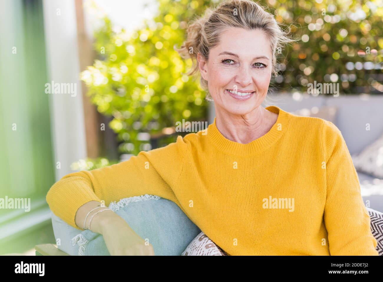 Portrait of smiling mature woman sitting on terrace Stock Photo - Alamy