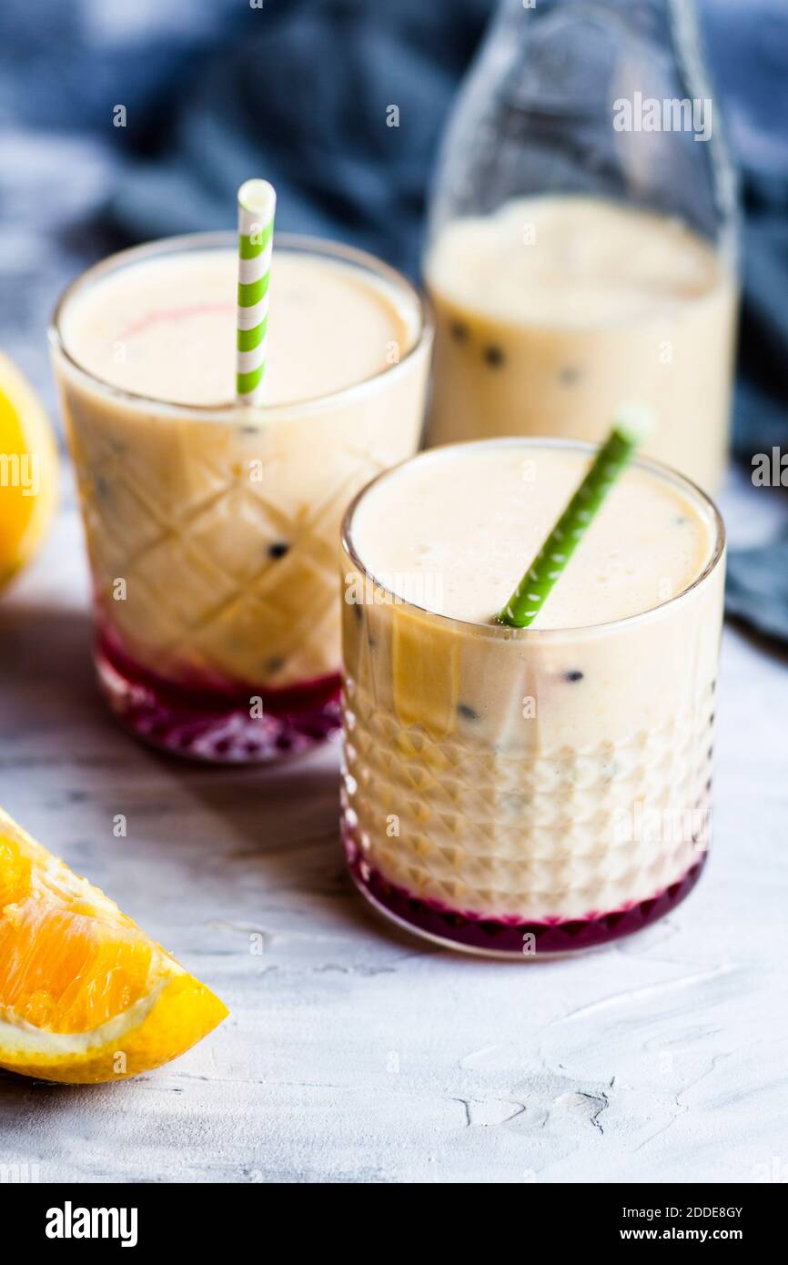 Glasses of fresh fruit smoothie with oranges, bananas, yogurt and grenadine Stock Photo