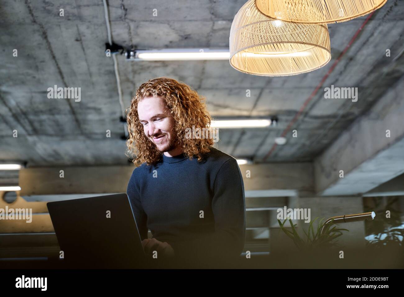 Smiling redhead man using laptop at home Stock Photo