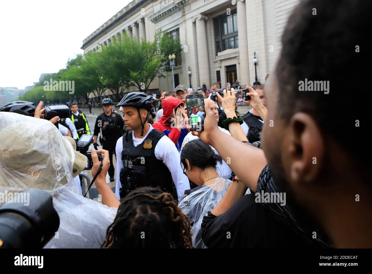 NO FILM, NO VIDEO, NO TV, NO DOCUMENTARY - A group of people are taken into a police barricade and cover their faces after being seen carrying a flag associated with white supremacists in front of the White House and chased by protestors on Sunday, August 12, 2018. Photo by Darryl Smith/TNS/ABACAPRESS.COM Stock Photo