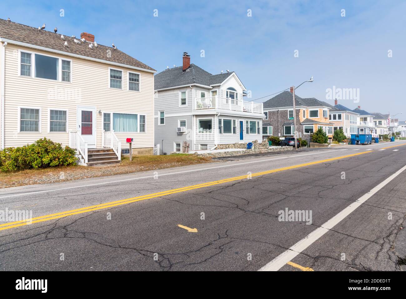 Detached houses along a deserted coastal road on a misty autumn day Stock Photo