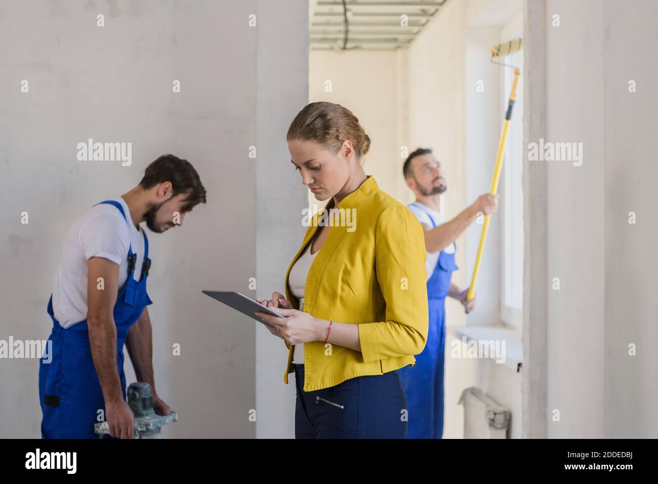 Female client evaluate the work of workers and write a note Stock Photo