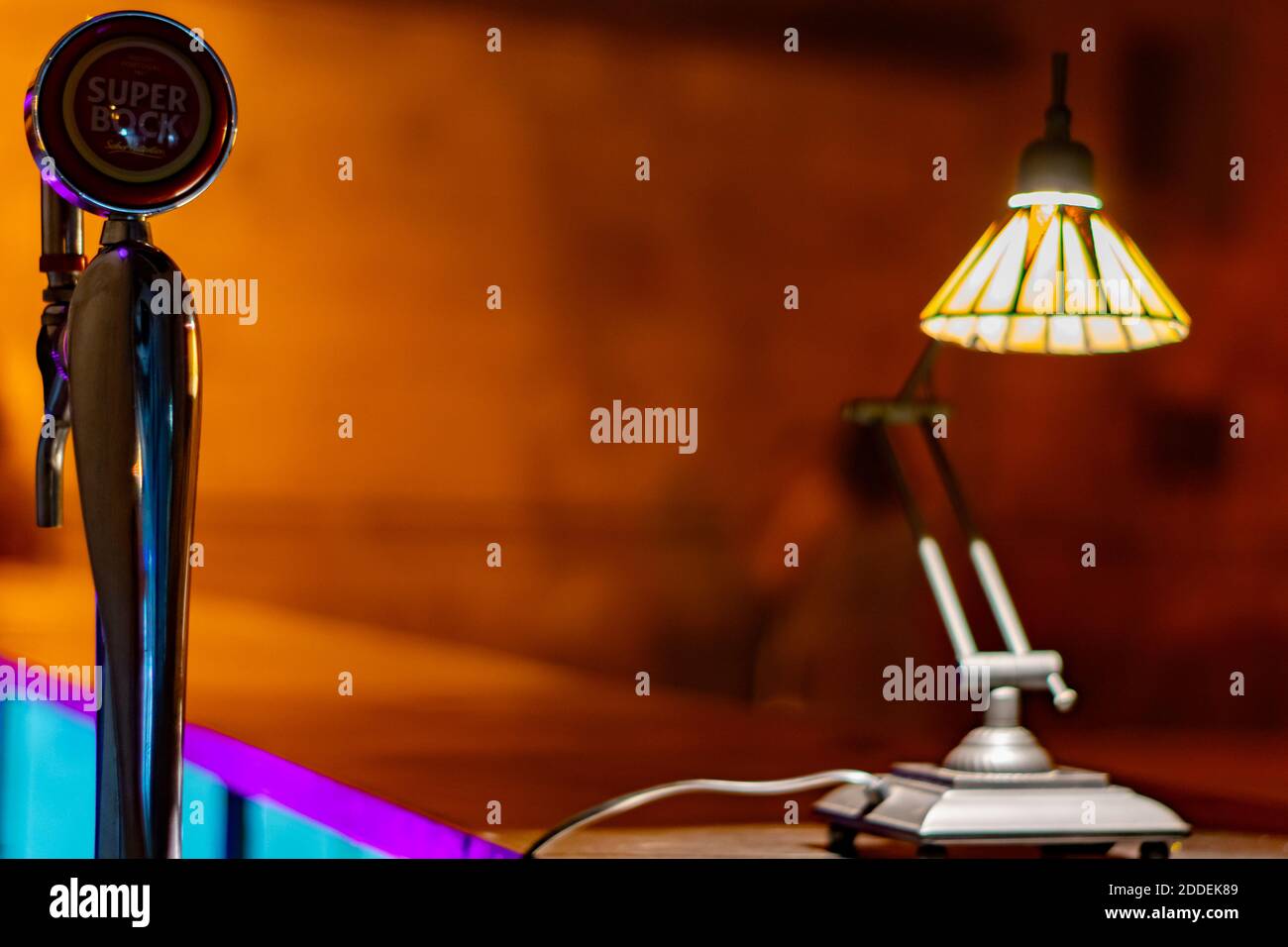 Night life concept with a lamp and a beer dispenser typically found on pubs and bars or discotheques. Night life concept. Empty pubs without people. Stock Photo