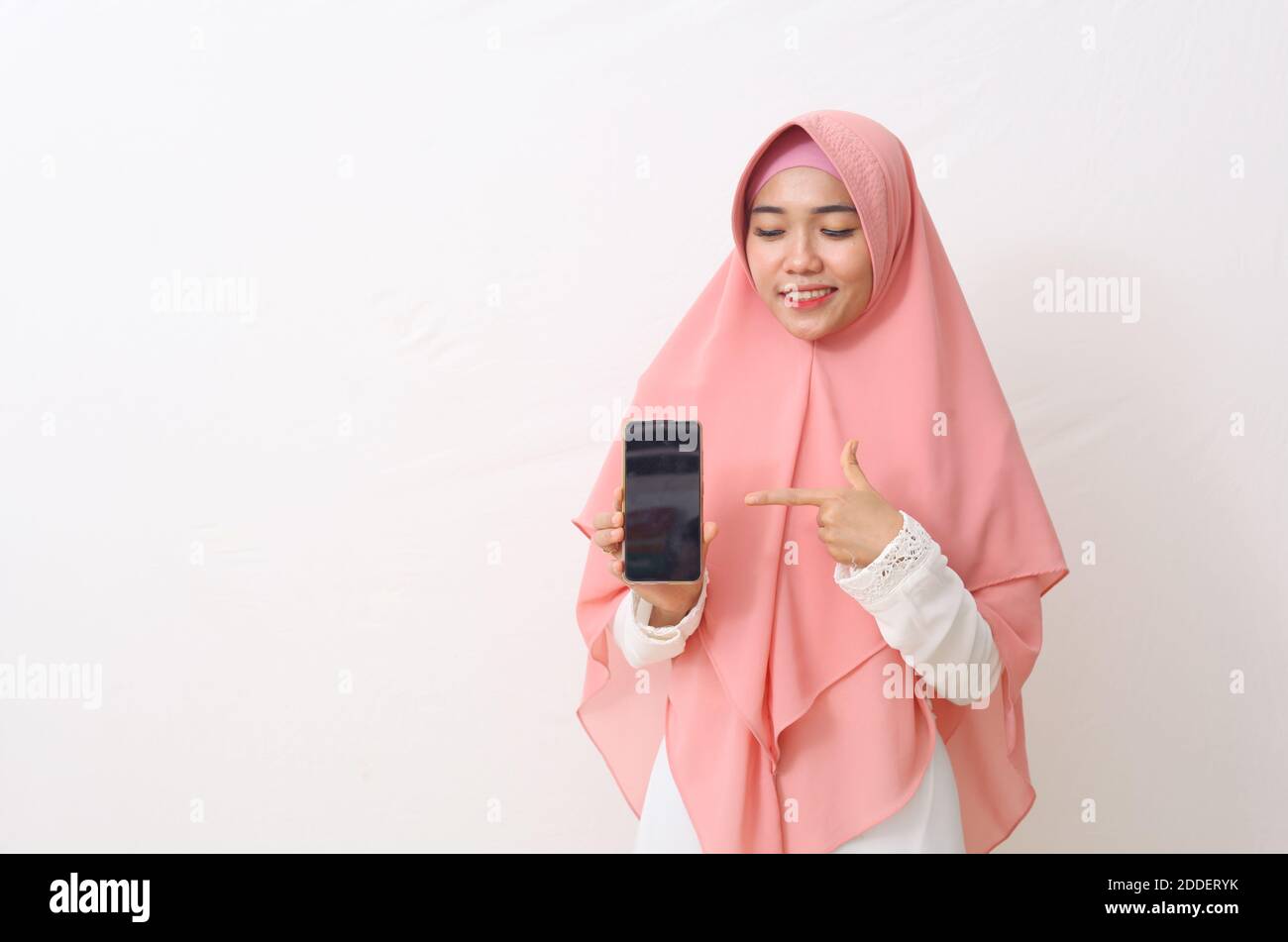 A portrait of happy asian muslim woman wearing a pink veil or hijab and ...