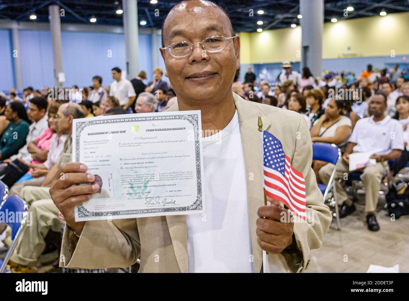 Florida,Miami Beach Convention Center,centre,naturalization ceremony oath of citizenship Pledge Allegiance,immigrants Asian man new citizen,hold holdi Stock Photo