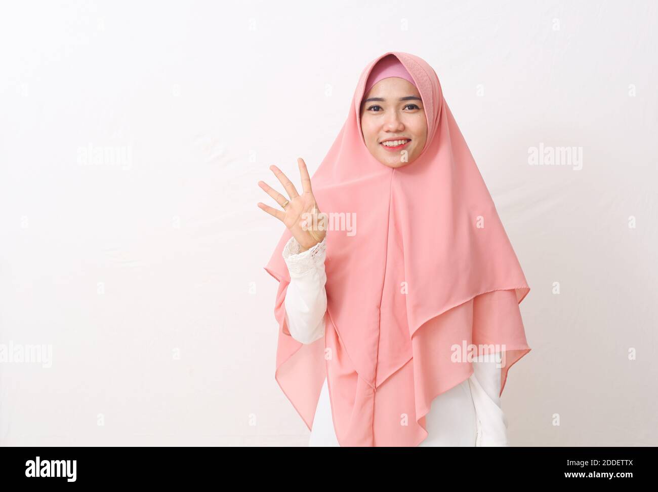 A portrait of happy asian muslim woman wearing a veil or hijab showing ...