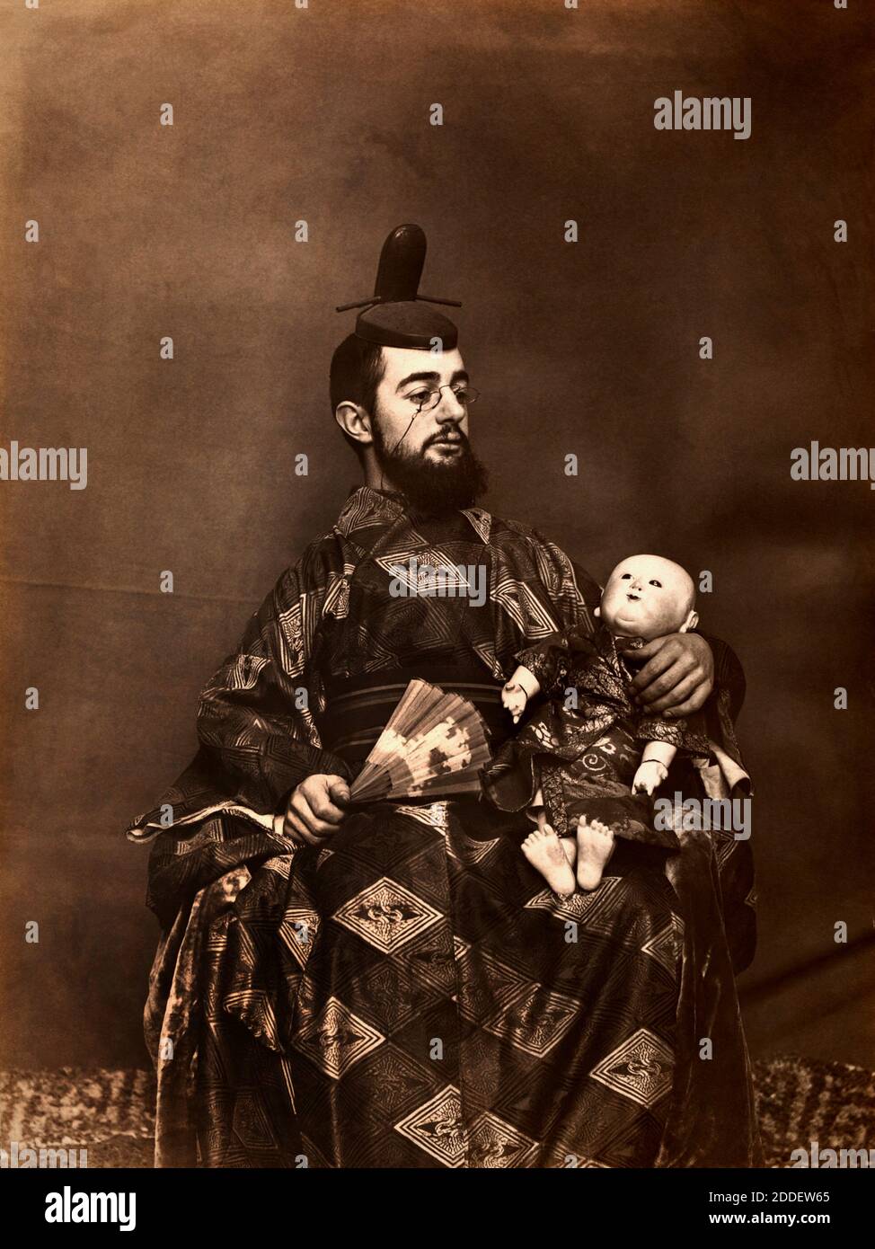 1883 , FRANCE : The celebrated french painter  Henry de TOULOUSE-LAUTREC ( 1864 - 1901 ) in Japan kimono costume with a fan and doll  . Photo by Maurice Guibert . - TOULOUSE LAUTREC - FOTO STORICHE - HISTORY - ARTS - ARTE - PITTURA  - PITTORE - artist - artista - portrait - ritratto - BELLE EPOQUE - occhi strabici - giapponese - Giappone - ORIENTALISMO - GIAPPONESISMO - IMPRESSIONISMO - IMPRESSIONISM - BAMBOLA orientale - ventaglio - pince-nez - lens - occhiali da vista - seta - silk  --- Archivio GBB Stock Photo