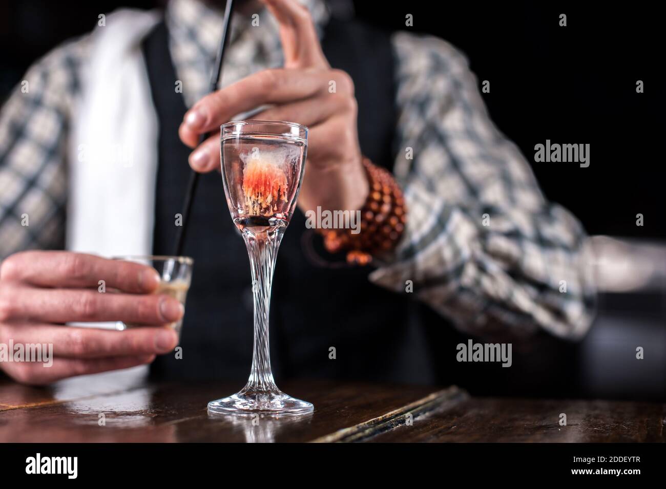 Charming tapster places the finishing touches on a drink behind the bar