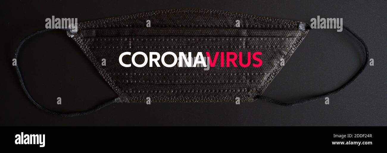 medical protective disposable black mask with CORONAVIRUS text. concept protection of outbreak novel dangerous 2019-nCoV influenza coronavirus, mutate Stock Photo