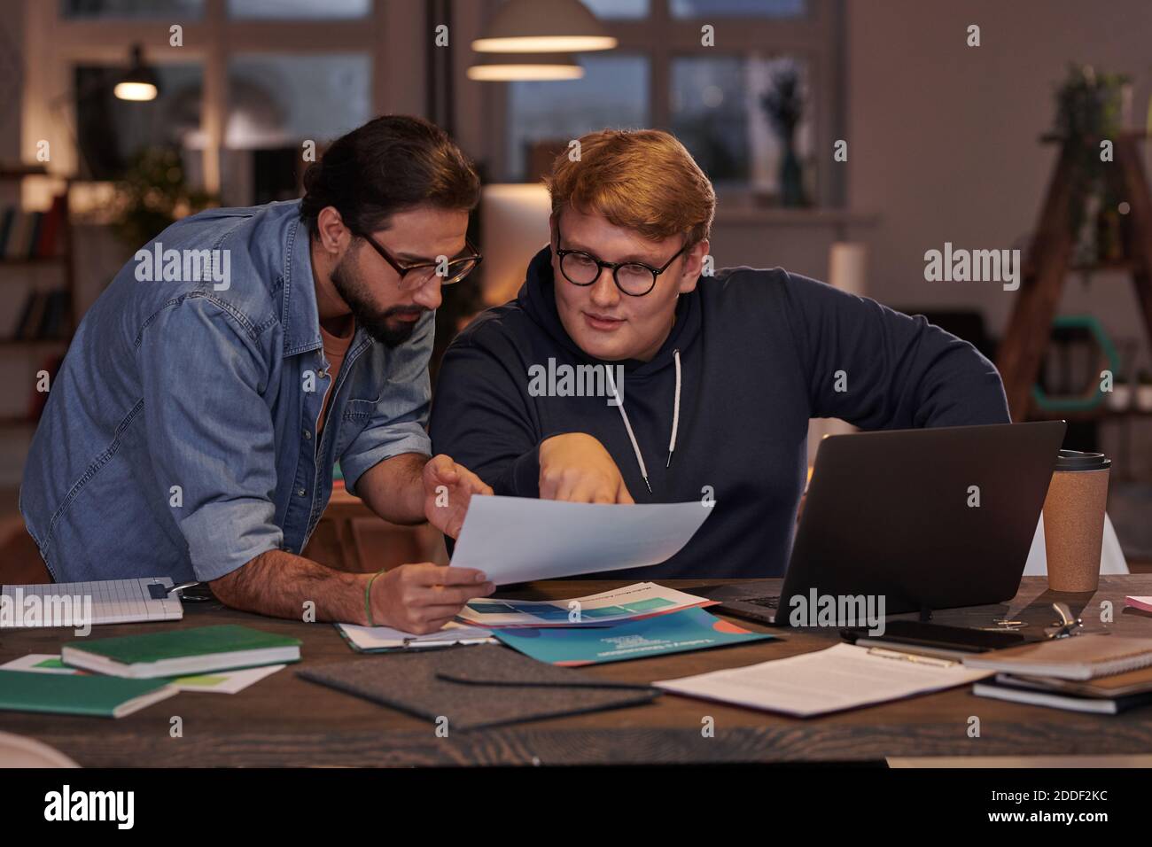 Two businessmen sitting at the table and discussing business documents in team working at office Stock Photo