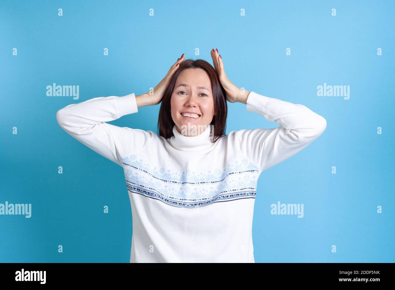 mock up smiling young Asian woman delighted with a nice surprise isolated on a blue background Stock Photo