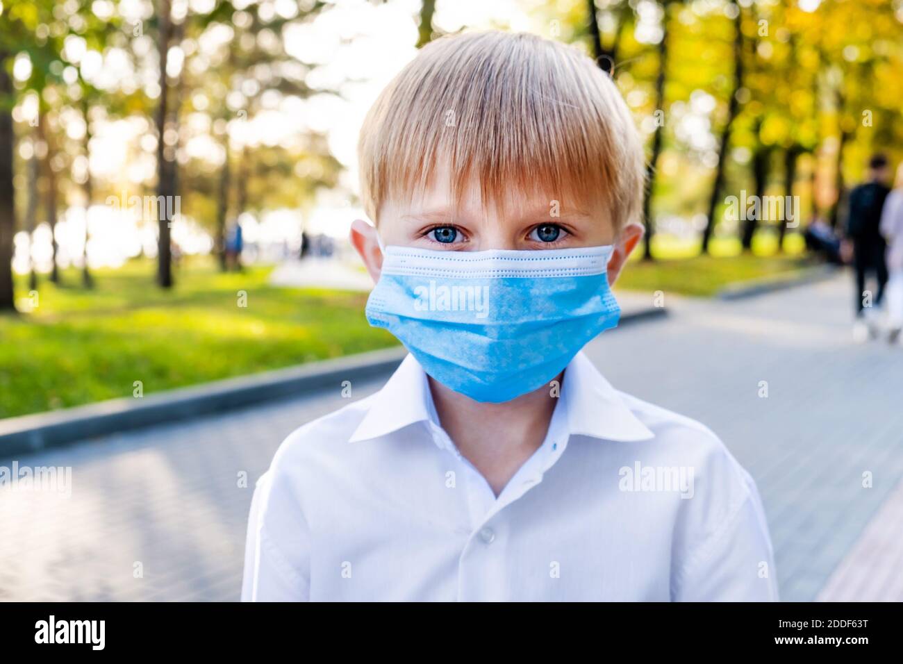 Portrait of a Kid in a Flu Mask on the City Street Stock Photo